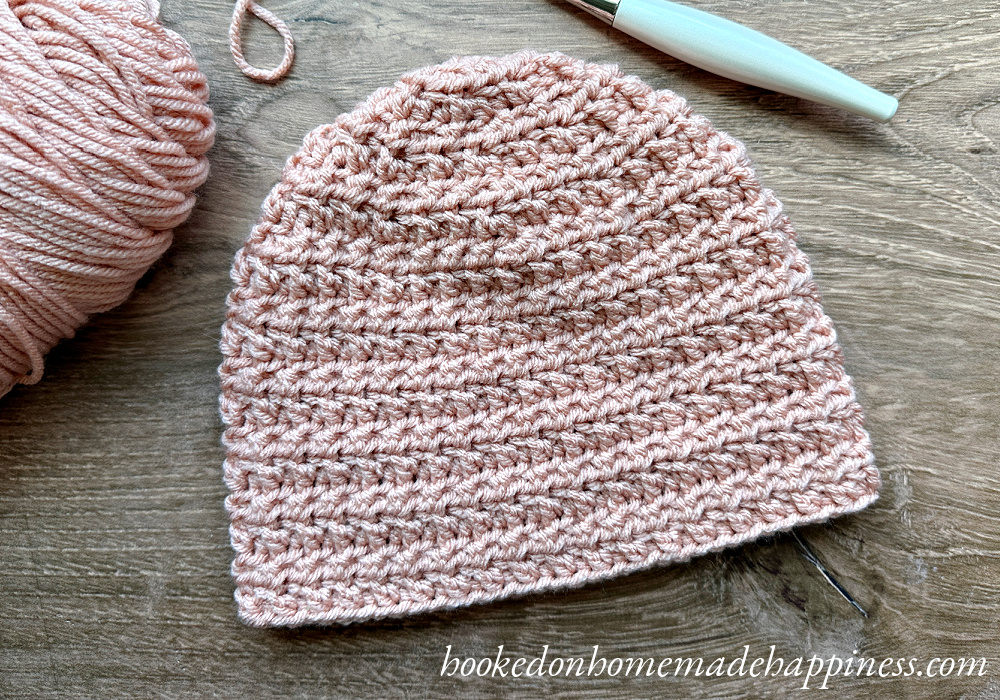 The Grid Beanie Crochet Pattern uses basic crochet stitches to create a subtle waffle or grid-like texture.